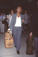 Sophia Loren in gray pants and jacket carrying basket suitcase at LAX photo print.