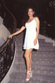 Constance Marie on stairs in white mini dress and heels photo print.