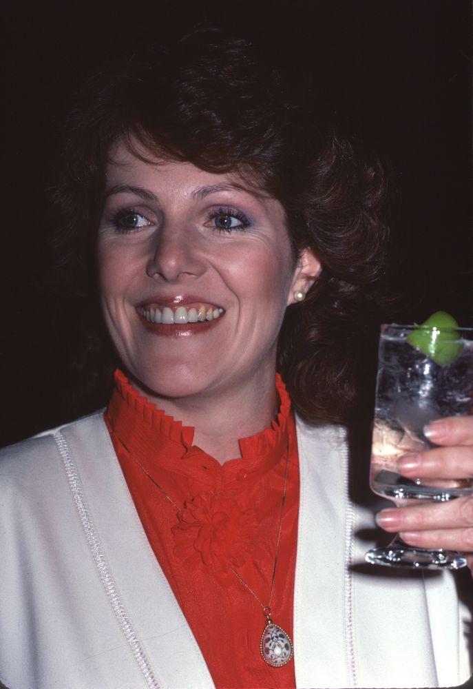 Close-up photo print of Lynn Redgrave holding a drink in a re-collared shirt.