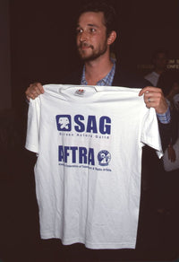 Noah Wyle holding 'Sag/Aftra' white shirt photo print.