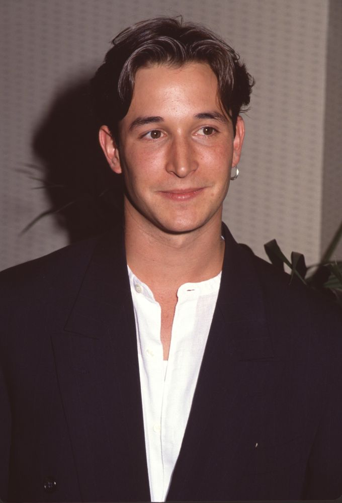 Noah Wyle closeup photo print in black jacket and unbuttoned white shirt.