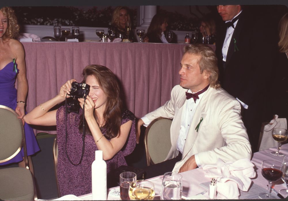 Hunter Tylo taking pictures next to Michael Tylo photo print.