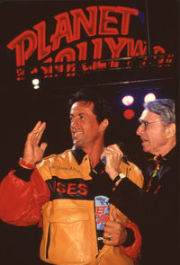 Sylvester Stallone waving on stage at Planet Hollywood photo print.