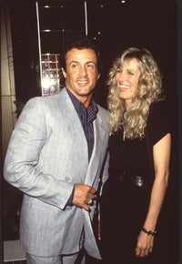 Sylvester Stallone in gray suit and Alana Stewart in black outfit with belt photo print