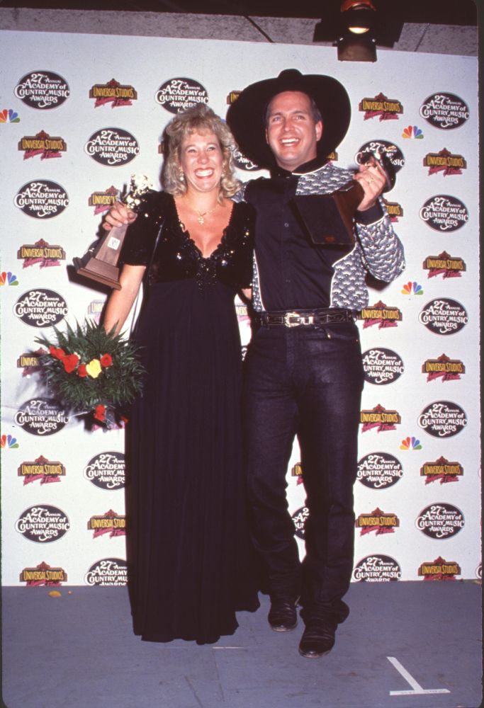 Sandy Brooks holding flowers in a black dress with Garth Brooks at the ACM Awards photo print