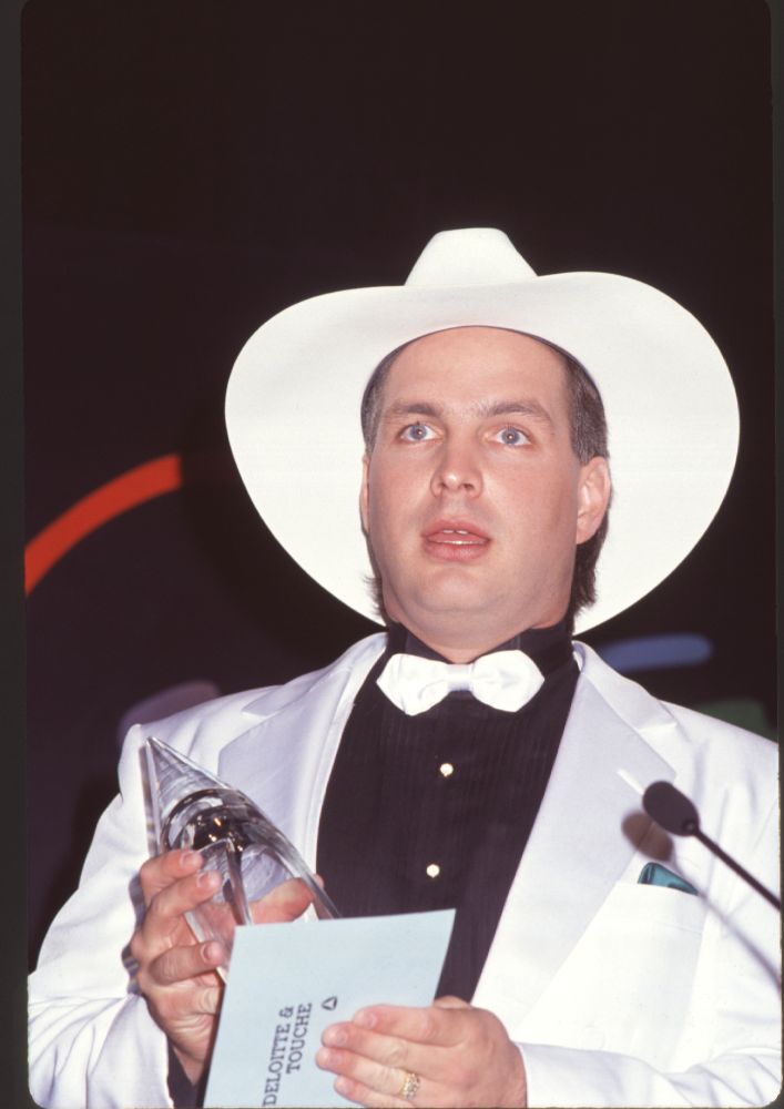 Garth Brooks close-up photo print in white tuxedo holding award.