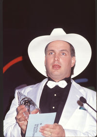 Garth Brooks close-up photo print in white tuxedo holding award.