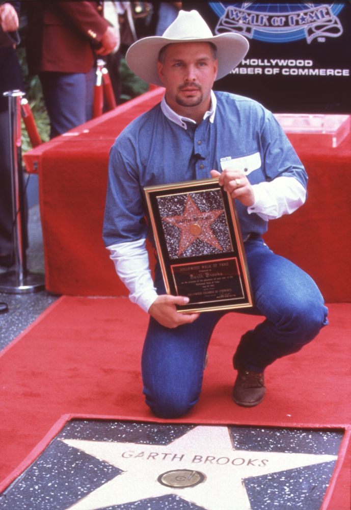Garth Brooks photo print in front of Hollywood star holding plaque.