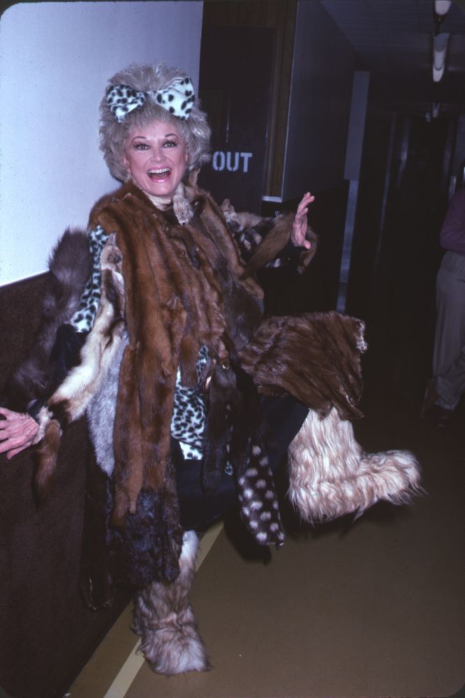 Photo print of Phyllis Diller wearing multiple furs, showcasing classic Hollywood style.