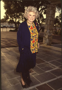 Phyllis Diller photo print in navy outfit with colorful top at Hollywood Park.