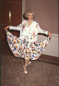 Phyllis Diller in white outfit with multicolored splatter dress photo print.