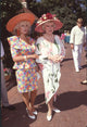 Josette Banzet in floral skirt suit and orange hat with Phyllis Diller in white dress with pink flowers and pink hat photo print.