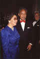 Joyce Dinkins in blue long sleeve dress with David Dinkins in tuxedo and red bowtie photo print.