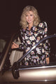Donna Mills getting into car in black and floral dress photo print.