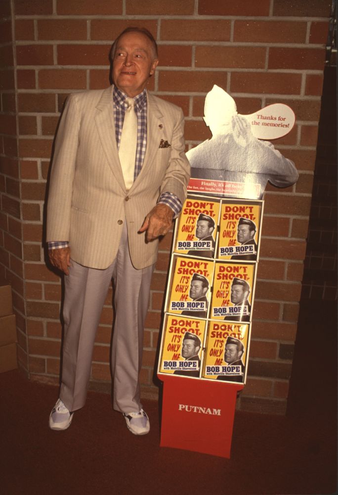 Bob Hope standing next to stack of books at a book signing event photo print.