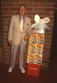 Bob Hope standing next to stack of books at a book signing event photo print.
