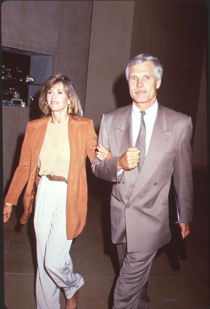 Photo print of Jane Fonda in an orange blazer with Ted Turner in a gray suit.