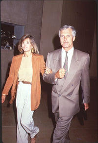 Photo print of Jane Fonda in an orange blazer with Ted Turner in a gray suit.