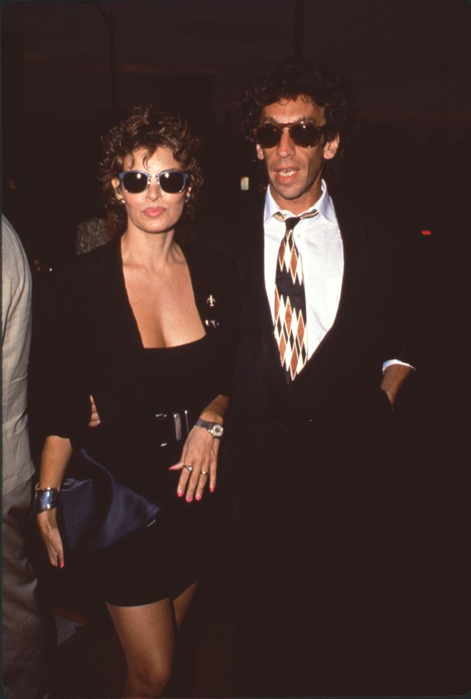 Raquel Welch in black mini skirt suit with André Weinfeld in sunglasses photo print.