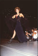 Raquel Welch on stage in black gown with sheer cape photo print