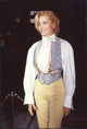 Geena Davis wearing yellow pants, high collar shirt, and vest photo print.