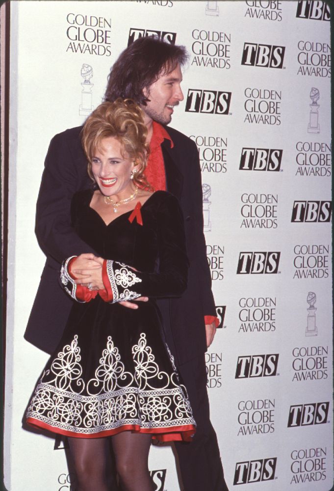 John Corbett holding Marlee Matlin in a black and white dress with red trim at the 51st Golden Globe Awards
