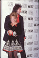 John Corbett holding Marlee Matlin in a black and white dress with red trim at the 51st Golden Globe Awards