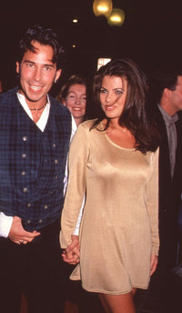 Ricky Paull Goldin in plaid vest with Yasmine Bleeth in gold dress at Planet Hollywood opening photo print.