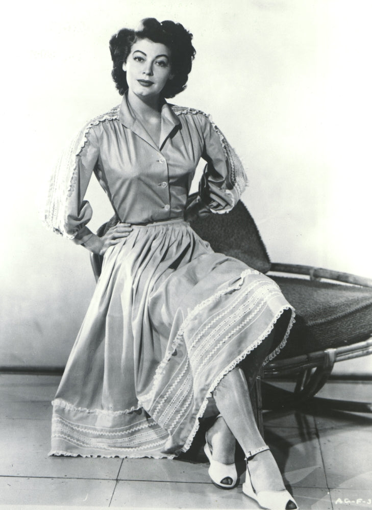 Ava Gardner Sitting in Chair Photo Print capturing classic Hollywood elegance.