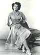 Ava Gardner Sitting in Chair Photo Print capturing classic Hollywood elegance.