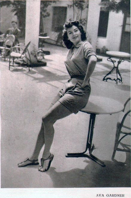 Ava Gardner Sitting on Table Photo Print capturing classic Hollywood elegance.