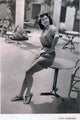 Ava Gardner Sitting on Table Photo Print capturing classic Hollywood elegance.