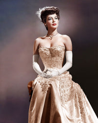 Ava Gardner wearing white gloves in a classic color photo print.