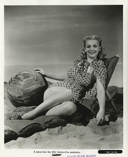 Carole Landis sitting in a beach chair with a beach ball photo print