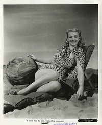 Carole Landis sitting in a beach chair with a beach ball photo print