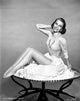 Cyd Charisse sitting on round coffee table photo print