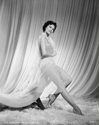 Cyd Charisse sitting on the edge of a chaise photo print.
