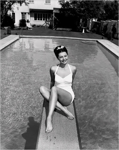 Cyd Charisse in white bathing suit on diving board photo print.