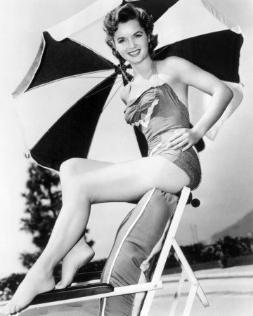 Debbie Reynolds sitting on a chair underneath an umbrella photo print.