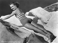 Debbie Reynolds laying on her stomach on rocks photo print.