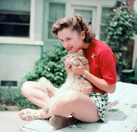 Debbie Reynolds holding a cat photo print, showcasing classic Hollywood charm.