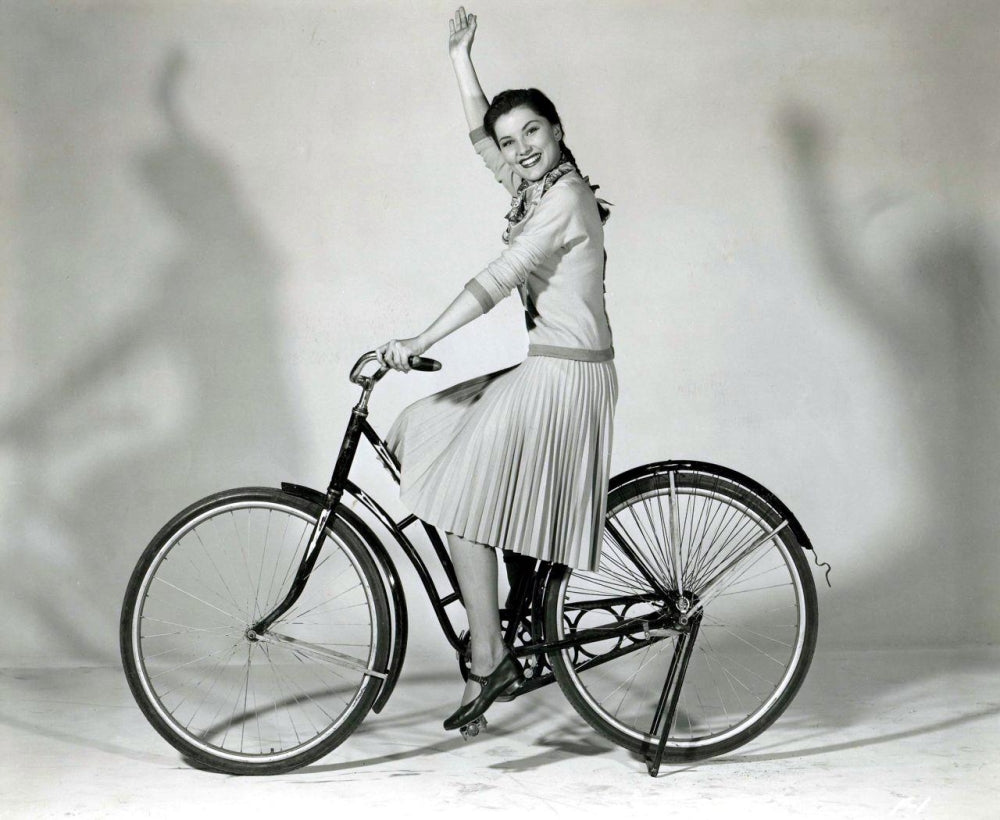 Debra Paget Riding a Bicycle Photo Print showcasing vintage photography art.