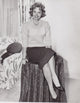 Donna Reed posed on table photo print, vintage Hollywood elegance.