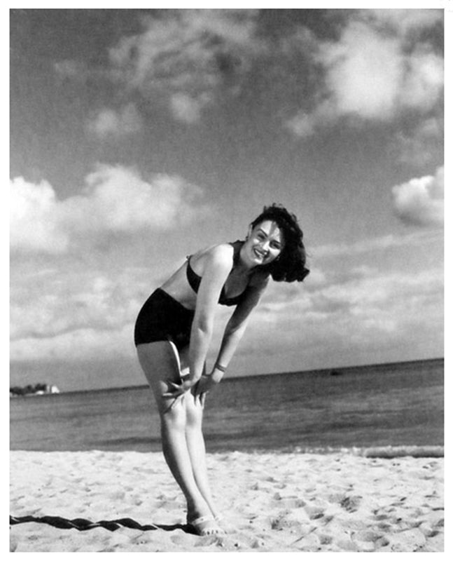 Vintage photo print of Donna Reed leaning over on the beach.