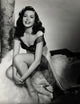 Ann Miller Sitting Photo Print capturing vintage Hollywood elegance.