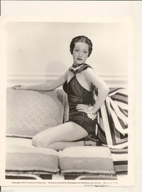 Dorothy Lamour photo print kneeling on couch with hand on hip.
