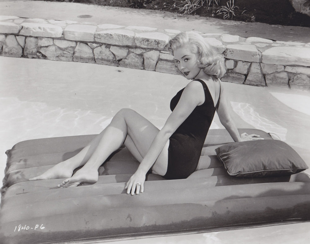 Elaine Stewart sitting on a colorful pool float - Photo Print