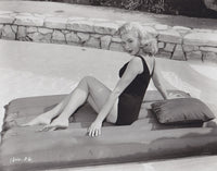 Elaine Stewart sitting on a colorful pool float - Photo Print