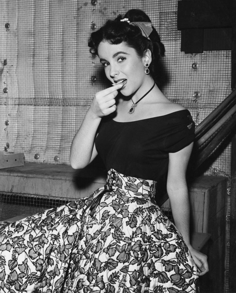 Elizabeth Taylor in a black dress with leaf pattern photo print.