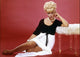 Elke Sommer leaning on a fur ottoman photo print.